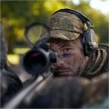 Boczny profil mężczyzny podczas polowania w czapce z daszkiem Härkila Deer Stalker. Zdjęcie eksponuje usztywniony daszek i materiał z wiatroszczelną membraną Härkila Weather System chroniącą przed warunkami atmosferycznymi.