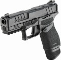 Zbliżenie pod niskim kątem na lewą stronę szkieletu, uwydatniające precyzyjną teksturę Adaptive Grip oraz ergonomiczną dźwignię zrzutu zamka i obustronny przycisk zwalniania magazynka.